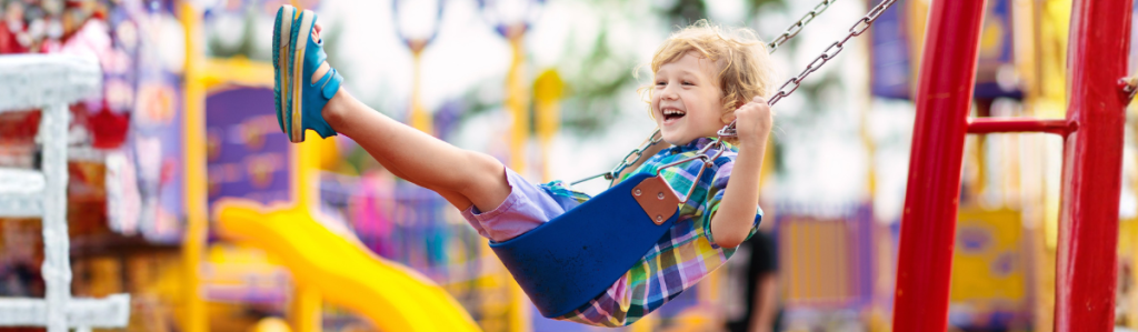 Enfant jouant sur une balançoire dans une aire de jeux sûre et conforme aux normes